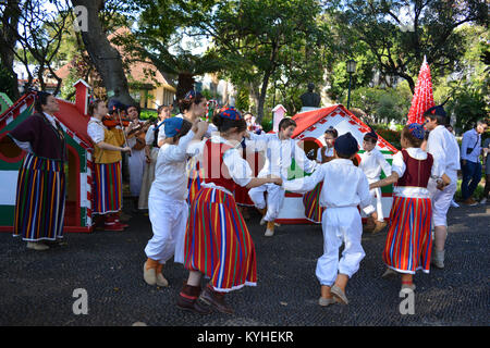 Group of young folk dancers and folk musicians  performing outdoors in the Municipal Gardens in Funchal, Madeira, at Christmas time. Stock Photo