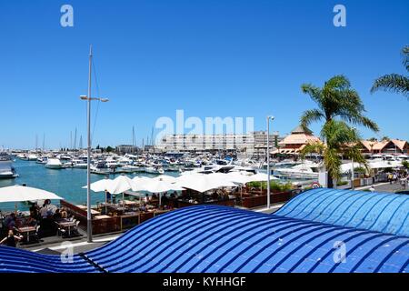 Luxury boats moored in the marina with waterfront restaurants in the foreground, Vilamoura, Algarve, Portugal, Europe. Stock Photo