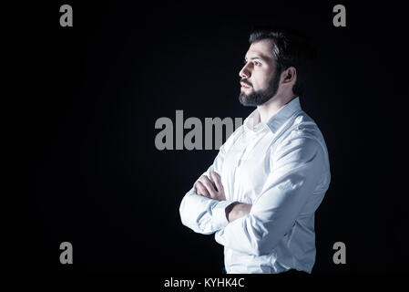 Serious bearded man standing cross handed Stock Photo