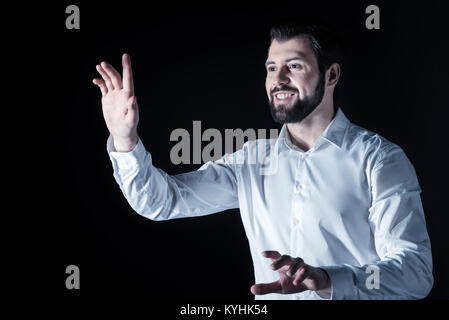 Happy delighted man using virtual technology Stock Photo
