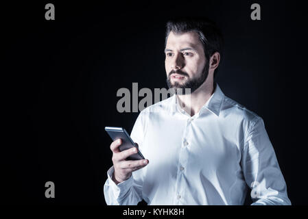 Serious handsome man using a smartphone Stock Photo