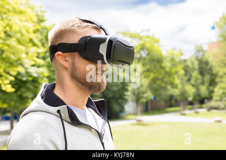 Attractive Bearded Man Enjoying Virtual Reality Glasses In Park Stock Photo