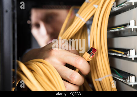 Close-up Of Engineer Plugging Cables Into Server In Data Center Stock Photo