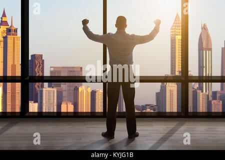Rear View Of A Businessman Looking Out Of A Window At The City Skyline Stock Photo