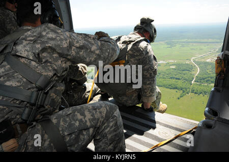 Soldiers with the Kentucky National Guard's 40th Special Forces Group jump from a UH-60 Blackhawk helicopter over Camp Atterbury, Indiana June 6, 2014. The Soldiers were taking part in a D-Day commemorative jump to pay tribute to the more than 2,000 paratroopers who lost their lives during the D-Day invasion in WWII. (Photo by Sgt. David Bolton, 133rd Mobile Public Affairs Detachment, Kentucky Army National Guard) Stock Photo