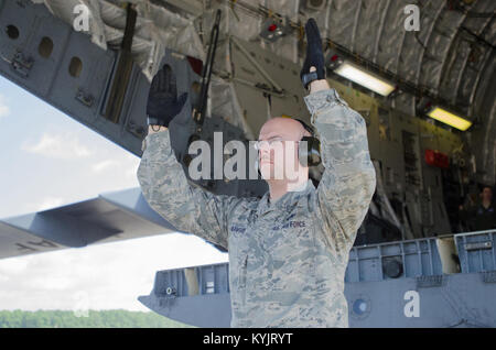 Tech. Sgt. Jerrod Blanford, an aerial porter from the Kentucky Air National Guard’s 123rd Contingency Response Group, spots a forklift as it unloads cargo from a Kentucky Air Guard C-130 Hercules during Capstone '14, a homeland earthquake-response exercise at Fort Campbell, Ky., on June 17, 2014. The 123rd CRG is joining with the U.S. Army’s 688th Rapid Port Opening Element to operate a Joint Task Force-Port Opening here from June 16 to 19, 2014. (U.S. Air National Guard photo by Master Sgt. Phil Speck) Stock Photo