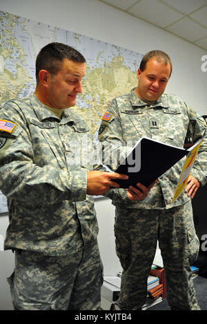 Lt. Col. Jason Shepherd and Capt. Spencer Robinson discuss a legal case file in Frankfort, Ky., Aug. 19, 2014. The members of the Kentucky Guard's Staff Judge Advocate General's office assist in handling a wide variety of legal cases on a daily basis. (U.S. Army National Guard photo by Staff Sgt. Scott Raymond)