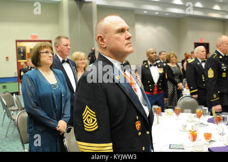 Kentucky National Guard State Command Sgt. Maj. Thomas Chumley, and hiw wife Wanda, listen to &quot;My Old Kentucky Home,&quot; sung by  Kentucky Army National Guard Spc. Stacy Pesut, human resources specialist assigned to Headquarters and Headquarters Detachment, 103rd Chemical Battaion, at the conclusion of the 2015 Outstanding Airman and Soldier of the Year Banquet March 14, 2015 at the Kentucky Fair and Exposition Center in Louisville, Kentucky. The annual awards dinner honors Kentucky's finest Airmen and Soldiers who are recognized by their peers for dedicating themselves to the welfare a Stock Photo