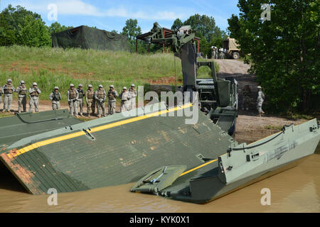 Soldiers of the 2061st Multi Role Bridge Company recover an interior bay of an improved ribbon bridge with a M1977 Common Bridge Transporter (CBT) as part of their annual training at Fort Knox Kentucky on 15 Jul 2016. (Kentucky National Guard photo by Walt Leaumont) Stock Photo