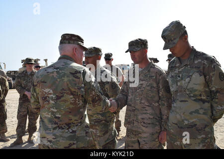 Spc. Jason Drake with the 207th Horizontal Constuction company receives a coin from Brig. Gen. Benjamin Adams III, Kentucky's Director of the Joint Staff, Mar. 4 during a visit to Camp Arifjan, Kuwait. Stock Photo