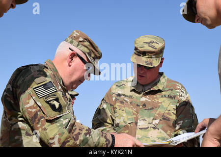 Staff Sgt. Santiamagro with the 207th Horizontal Construction Company, right, shows Brig. Gen. Benjamin Adams III, Kentucky's director of the joint staff, the details of project site Mar. 4 at Camp Arifjan, Kuwait. Stock Photo