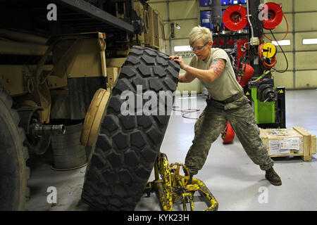 Staff Sgt. Kathleen Braithwaite removes a wheel from a M977 Heavy Expanded Mobility Tactical Truck (HEMTT) in Frankfort, Ky., March 16, 2017. (U.S. Army National Guard photo by Staff Sgt. Scott Raymond) Stock Photo