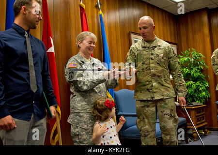 Staff Sgt. Birgit Corriveau receives a personalized NCO sword from Command Sgt. Maj. David Munden during a ceremony in Frankfort, Ky., May 24, 2017. Corriveau retired after 28 years of service. (U.S. Army National Guard photo by Staff Sgt. Scott Raymond) Stock Photo