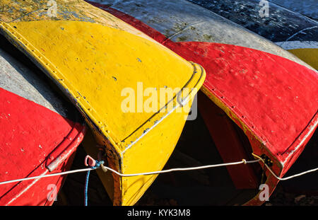 the hulls of upturned brightly coloured boats Stock Photo