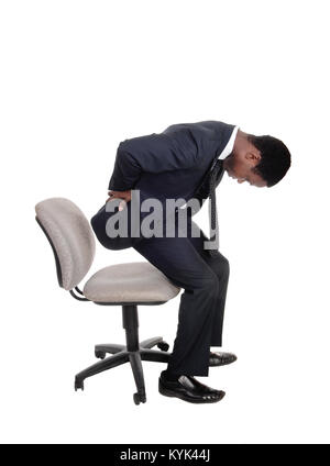 A young business man in a suit getting up from his office chair holding  his back for back pain, isolated for white background Stock Photo