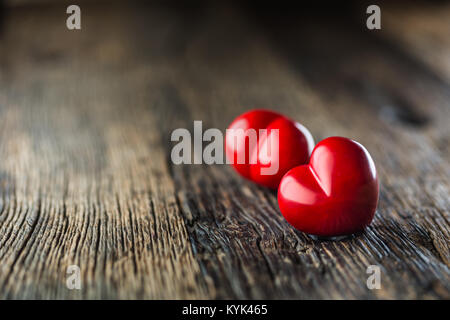 Valentines red heart. One two red heart on wooden table. Wedding or valentine day. Stock Photo