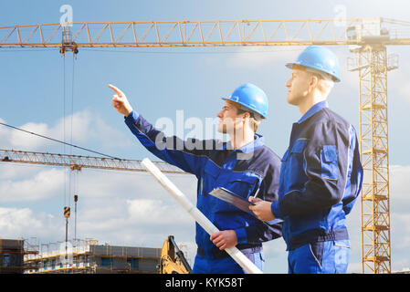 Two Young Male Architect Engineer Discussing At Construction Site Stock Photo