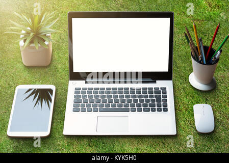Close Up Of Laptop And Digital Tablet On Green Grass Stock Photo