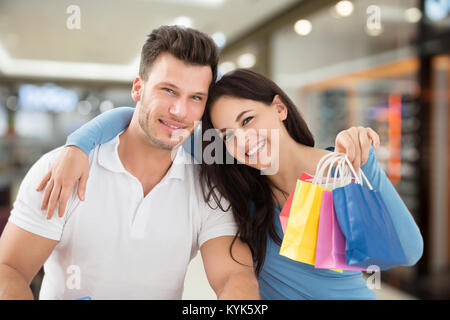 Portrait Of Young Smiling Couple With Small Multi Colored Shopping Bags Stock Photo