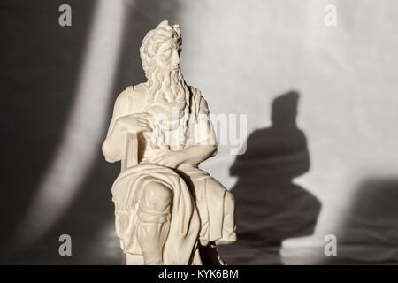 Replica of Michelangelo Moses sculpture, very popular as Rome souvenir. Studio take over wrinkled white fabric Stock Photo