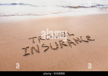 travel insurance concept, text words written on the sand Stock Photo
