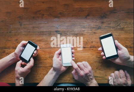 social networking concept, many hands with smartphones gadgets on wooden background Stock Photo