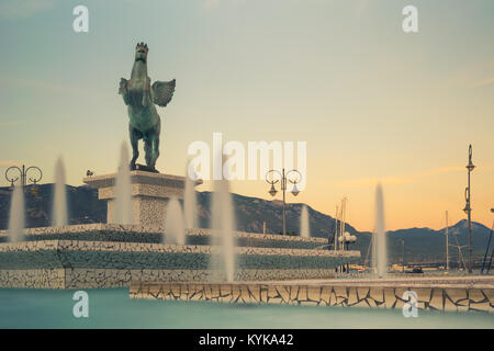 Corinth, Greece, 5 October 2017. Central square of Corinth in Greece with pegasus statue against a beautiful sunset. Stock Photo