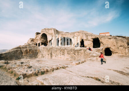 Uplistsikhe, Shida Kartli Region, Georgia - October 27, 2016: Woman Walking Near Temple With Coffered Ceilings In Famous Landmark Uplistsikhe. Ancient Stock Photo