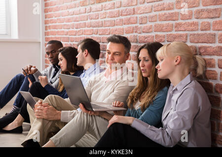 Group Of Diverse Businesspeople Using Laptops And Digital Tablets Stock Photo