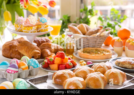 Breakfast or brunch table filled with all sorts of delicious delicatessen ready for an Easter meal. Stock Photo