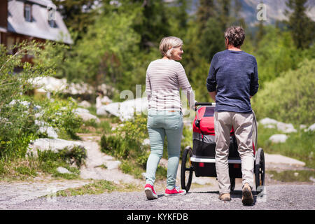 Senior couple with a jogging stroller, summer day. Stock Photo