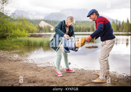 Senior couple with little boy at the lake. Stock Photo