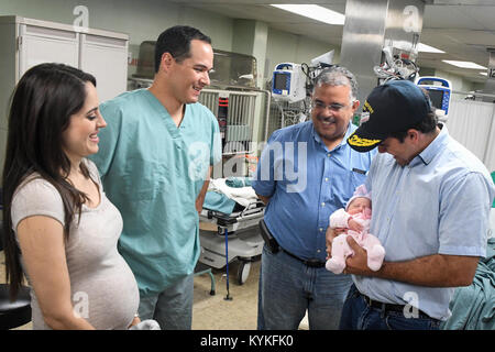 CARIBBEAN SEA (Oct. 15, 2017) Puerto Rico Gov. Ricardo Rossello holds the first child born aboard the U.S. Navy hospital ship USNS Comfort (T-AH 20) in more than seven years. Comfort is underway operating in the vicinity of San Juan, Puerto Rico, to provide medical services with additional visits being planned around the island. The U.S. Health and Human Services and Puerto Rico Department of Health representatives are prioritizing patients at each stop prior to Comfort's arrival. The Department of Defense is supporting the Federal Emergency Management Agency, the lead federal agency, in helpi Stock Photo