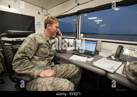 Maj. Ryan Adams, airflow operations officer for the Kentucky Air National Guard’s 123rd Contingency Response Group, coordinates with higher headquarters to control the airflow of simulated disaster-relief supplies into MidAmerica St. Louis Airport in Mascoutah, Ill., on Aug. 7, 2013, as part of Exercise Gateway Relief, a U.S. Transportation Command-directed earthquake-response scenario. Adams was working in a portable structure called a HELAMS, which is short for Hard-sided Expandable Lightweight Air Mobile Shelter. (U.S. Air National Guard photo by Maj. Dale Greer/Released) Stock Photo