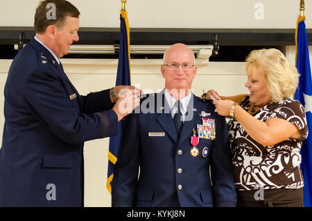 Maj. Gen. Mark Kraus’ wife (right) and Kentucky's adjutant general, Maj. Gen. Edward Tonini, pin the rank insignia of major general to Kraus’ uniform during a promotion ceremony at the Kentucky Air National Guard Base in Louisville, Ky., Aug. 18, 2013. Kraus is a Kentucky Air Guardsman who serves as Air National Guard assistant to the commander of U.S. Air Forces Central. (U.S. Air National Guard photo by Airman Joshua Horton) Stock Photo