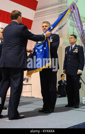 Col. Barry Gorter (center), incoming commander of the 123rd Airlift Wing, accepts the unit guidon from Maj. Gen. Edward Tonini, Kentucky’s adjutant general, during a change-of-command ceremony at the Kentucky Air National Guard Base in Louisville, Ky., Nov. 24, 2013, as Col. Warren Hurst (right), the outgoing wing commander, observes. Hurst has been named Kentucky’s assistant adjutant general for Air. (U.S. Air National Guard photo by Staff Sgt. Vicky Spesard) Stock Photo