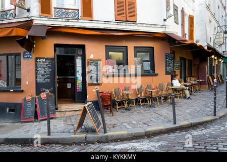 PARIS - Jan 2, 2014: Cafe in the Montmartre neighborhood. Typical place with sidewalk tables and handwritten menus. Stock Photo