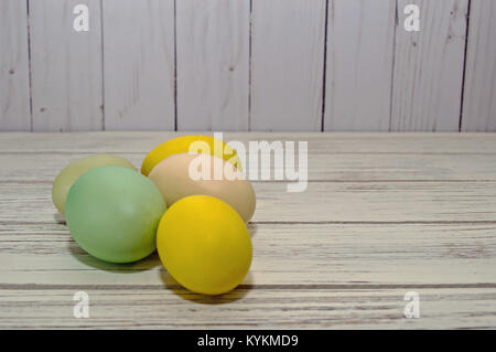 Several different colored Easter eggs on a wooden table Stock Photo