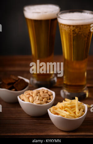 Pub beer snacks. Potato sticks, salted peanuts and rye garlic croutons. Stock Photo
