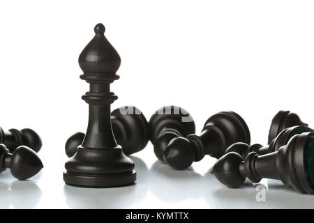 Runner chess figure standing in between fallen over pawn chess figures - management, leadership, teamlead or strategy concept over white background Stock Photo