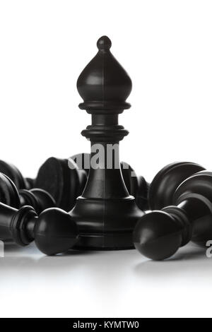 Runner chess figure standing in between fallen over pawn chess figures - management, leadership, teamlead or strategy concept over white background Stock Photo