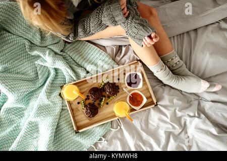 Unrecognizable woman and breakfast on bed Stock Photo