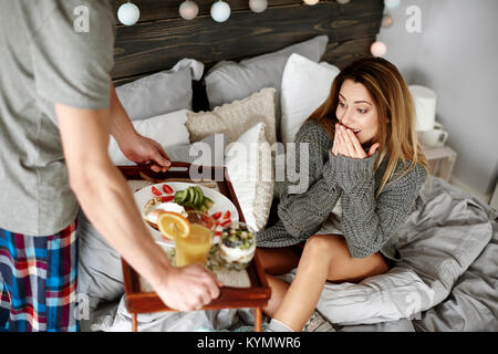 Man bringing surprised woman breakfast Stock Photo