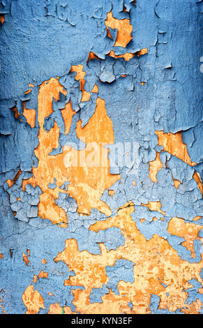 Crumbling flaking retro blue paintwork on an old and aging plaster wall showing signs of aging as the weathered brickwork begins to fade in color and  Stock Photo