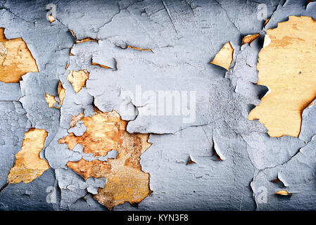 Crumbling flaking retro blue paintwork on an old and aging plaster wall showing signs of aging as the weathered brickwork begins to fade in color and  Stock Photo