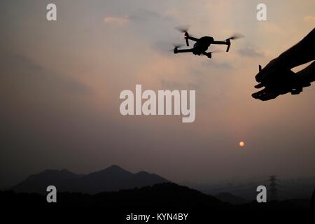 Flying drone in mountains at sunset. Stock Photo