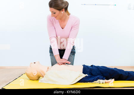 Woman in first aid course practicing heart massage Stock Photo