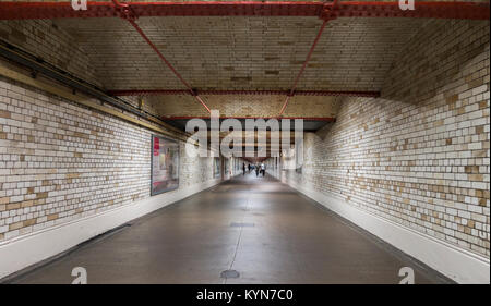 Subway beneath the road leading to South Kensington underground tube station, with people walking in the distance. London SW7, England, UK. Stock Photo