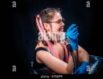 Professional tattooer poses for the camera in a tattoo studio Stock Photo