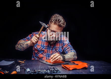 Worker of leather creating new leatherwork at studio Stock Photo
